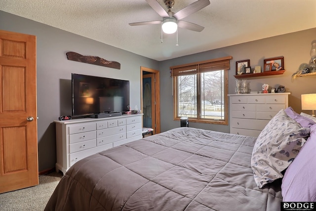 carpeted bedroom featuring a textured ceiling and a ceiling fan