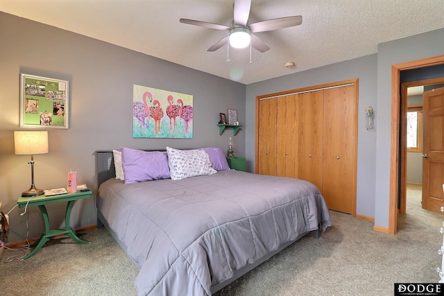 carpeted bedroom with a closet, baseboards, a textured ceiling, and a ceiling fan