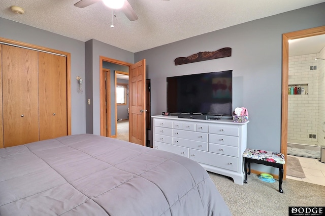 bedroom featuring carpet, ceiling fan, a closet, ensuite bathroom, and a textured ceiling