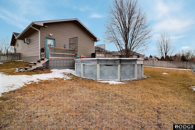 view of property exterior featuring a lawn, a wall mounted AC, fence, and a fenced in pool