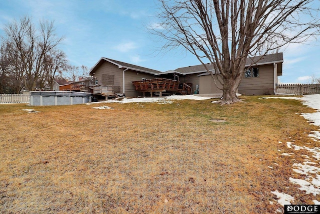 back of house featuring a wooden deck, a yard, a fenced in pool, and fence