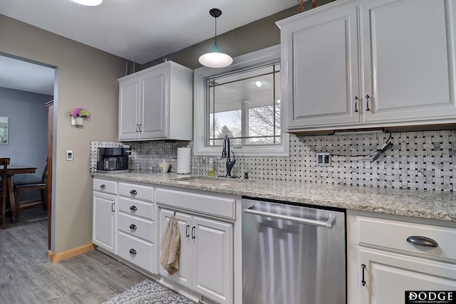 kitchen featuring a sink, white cabinets, dishwasher, tasteful backsplash, and light wood-type flooring