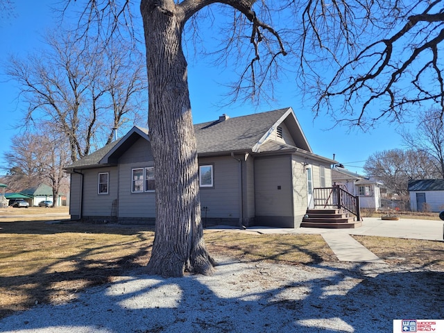 view of side of home featuring a shingled roof