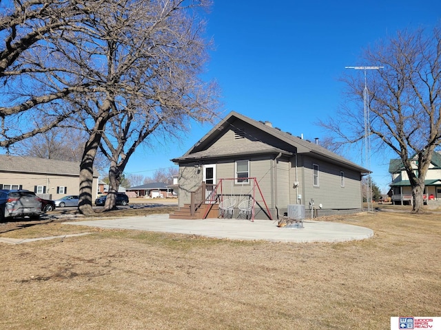 view of front of home with central AC and a front lawn