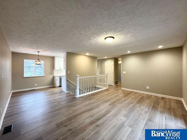 spare room with visible vents, recessed lighting, baseboards, and wood finished floors