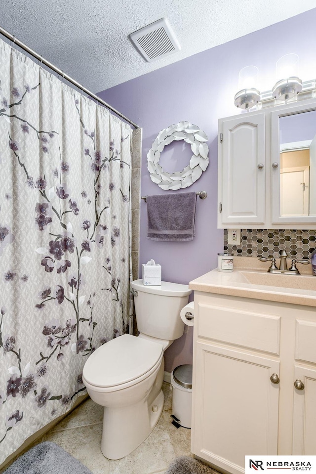 bathroom featuring vanity, visible vents, a textured ceiling, tile patterned floors, and toilet