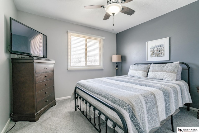 bedroom with light colored carpet, a ceiling fan, and baseboards