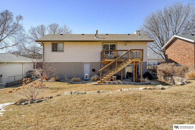 back of property featuring a yard, brick siding, a deck, and stairs