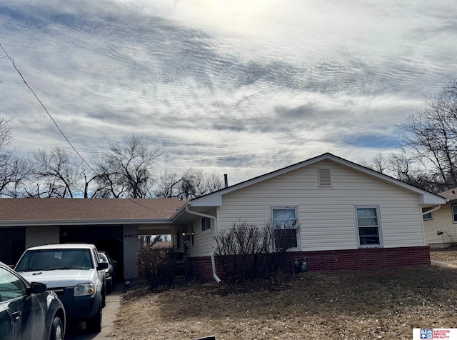 view of side of home with brick siding and roof with shingles