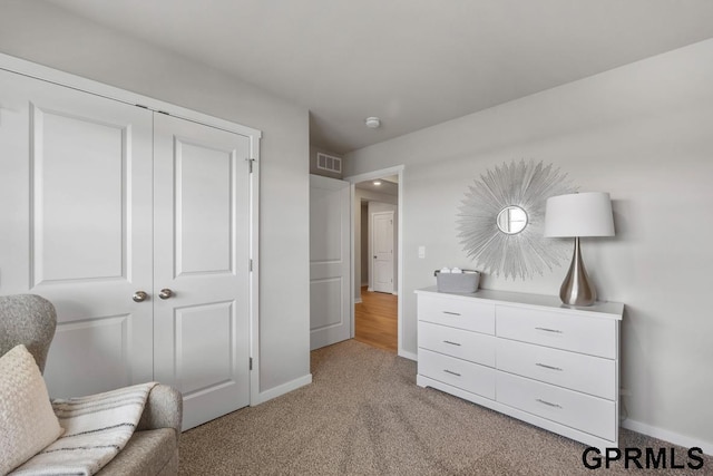 sitting room featuring visible vents, light colored carpet, and baseboards