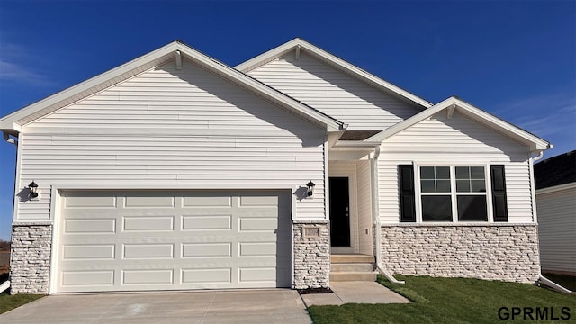 view of front of home featuring driveway, a garage, and stone siding