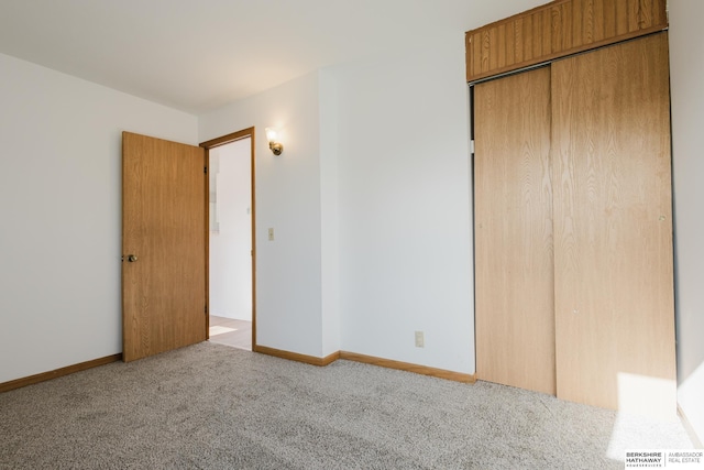 unfurnished bedroom with a closet, baseboards, and carpet