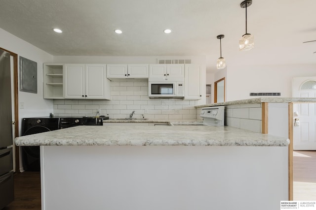 kitchen with white microwave, washer / clothes dryer, decorative backsplash, stove, and white cabinetry