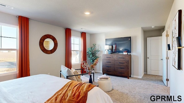 bedroom featuring light carpet, visible vents, and baseboards