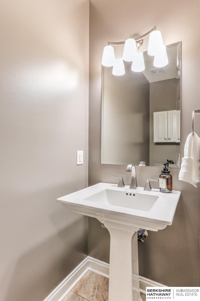 bathroom featuring tile patterned flooring, baseboards, and a sink