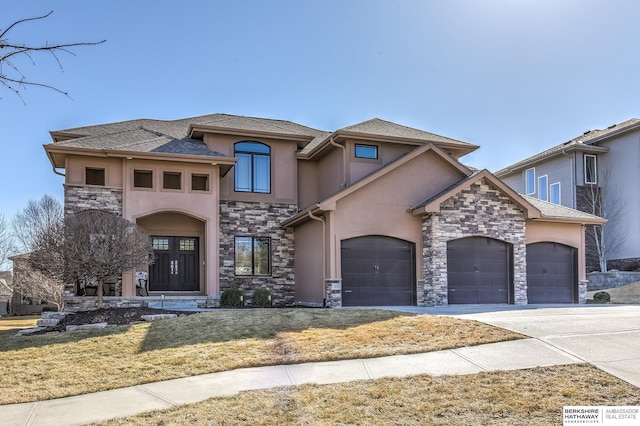 view of front of home with an attached garage, stone siding, and stucco siding