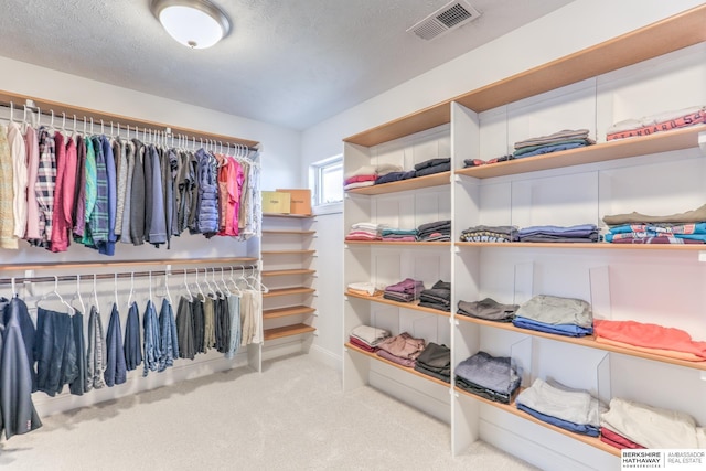 walk in closet featuring visible vents and carpet floors