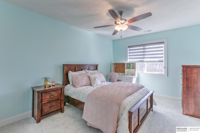 bedroom with visible vents, light colored carpet, baseboards, and ceiling fan