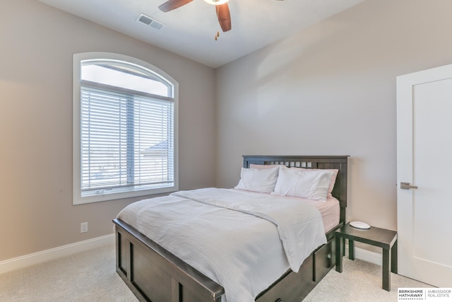 carpeted bedroom with visible vents, baseboards, and a ceiling fan