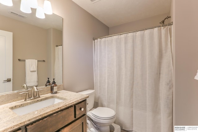 bathroom featuring vanity, toilet, and visible vents