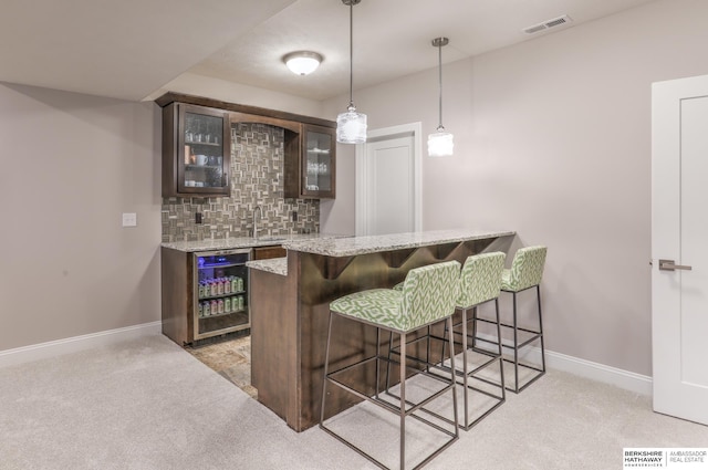 bar with visible vents, beverage cooler, light carpet, decorative backsplash, and wet bar