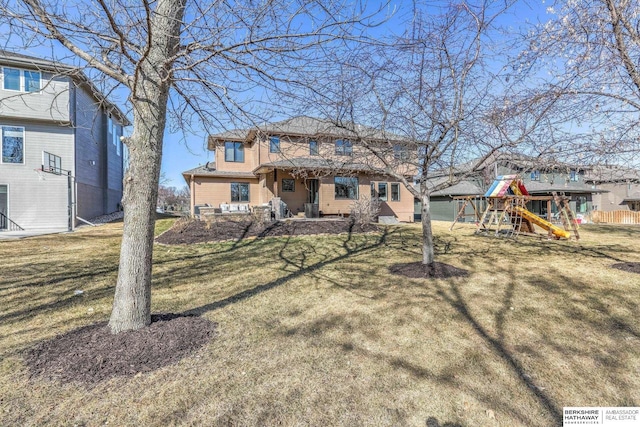 rear view of property featuring a yard and a playground