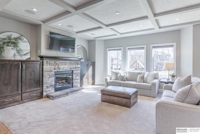 living area featuring plenty of natural light, beamed ceiling, coffered ceiling, and a fireplace