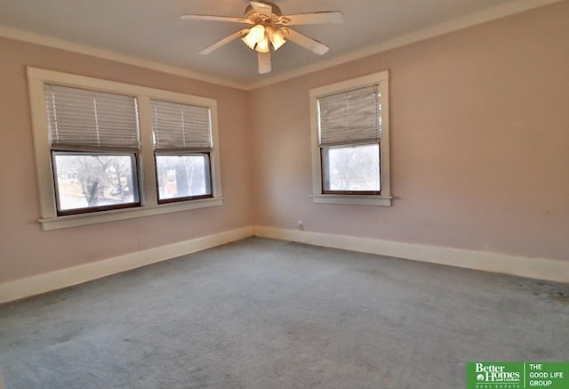 carpeted spare room with crown molding, baseboards, and ceiling fan