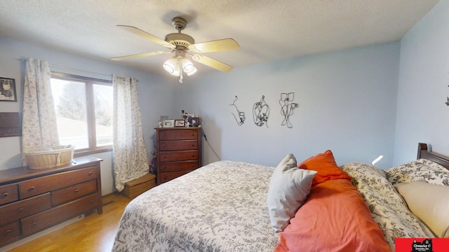 bedroom featuring a ceiling fan, light wood-style floors, and a textured ceiling