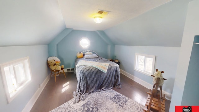 bedroom featuring lofted ceiling, wood finished floors, visible vents, and baseboards