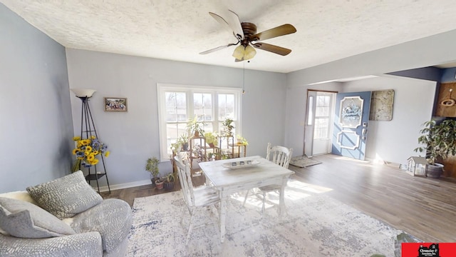 interior space with ceiling fan, wood finished floors, baseboards, and a textured ceiling