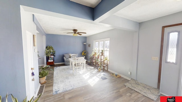 foyer entrance featuring a ceiling fan, baseboards, and wood finished floors