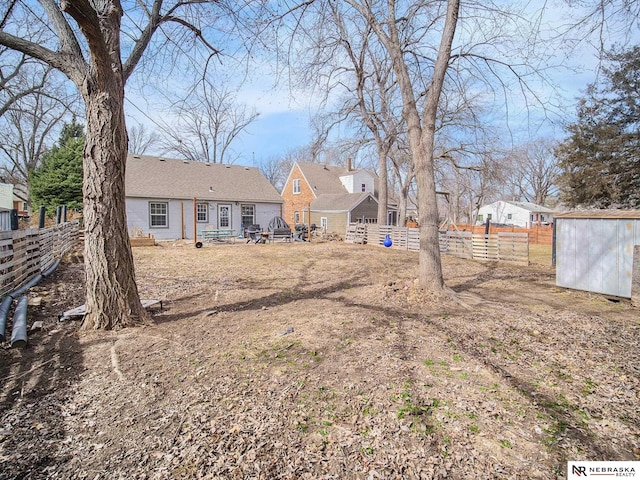 view of yard featuring an outdoor structure, fence, and a shed