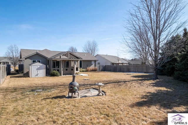 view of front facade with a shed, a front lawn, an outdoor structure, and a fenced backyard