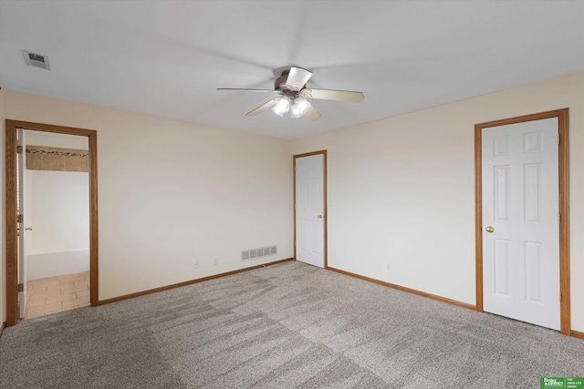 spare room featuring carpet flooring, baseboards, visible vents, and ceiling fan