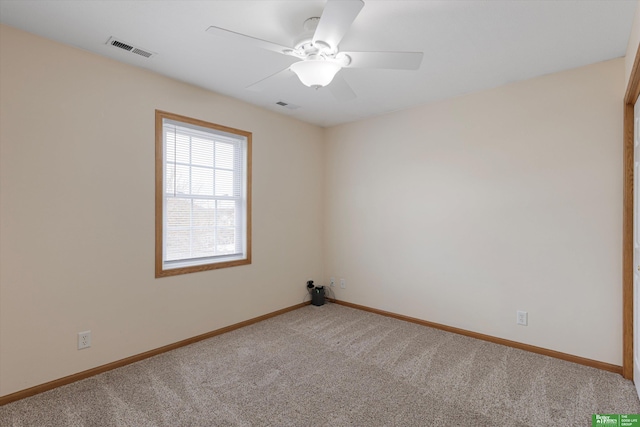 spare room featuring visible vents, a ceiling fan, baseboards, and carpet floors