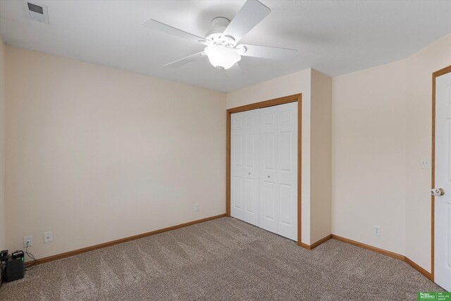 unfurnished bedroom featuring visible vents, baseboards, carpet floors, a closet, and a ceiling fan