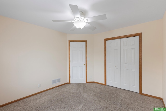 unfurnished bedroom featuring carpet flooring, baseboards, visible vents, and a closet