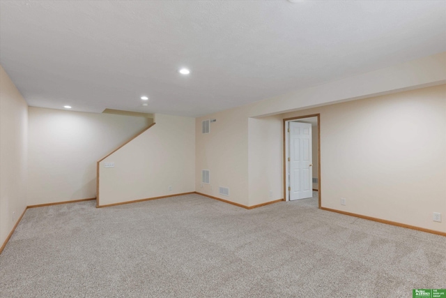 finished below grade area with recessed lighting, visible vents, baseboards, and light colored carpet