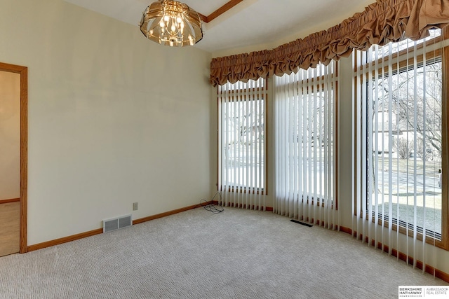 unfurnished room featuring a wealth of natural light, visible vents, and carpet flooring