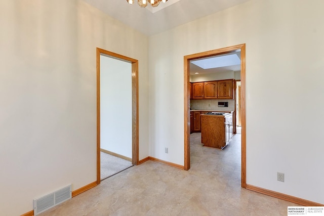 hallway featuring visible vents, baseboards, and a chandelier