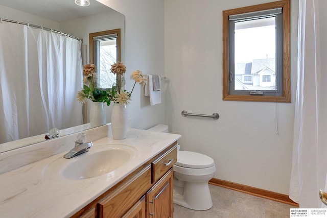 full bathroom featuring toilet, vanity, and baseboards