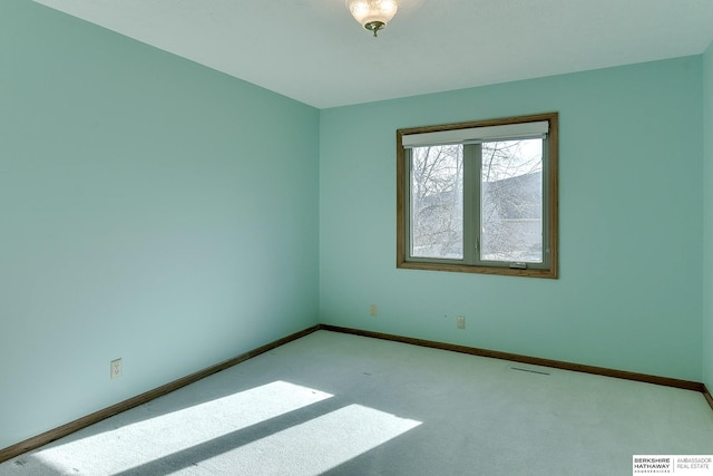 unfurnished room with visible vents, baseboards, and carpet floors