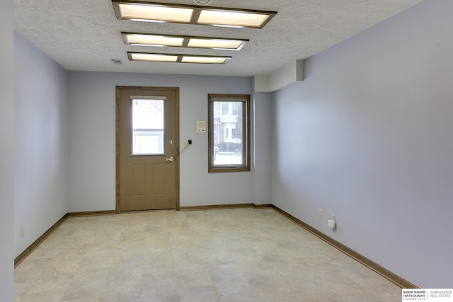 entryway featuring baseboards and a textured ceiling