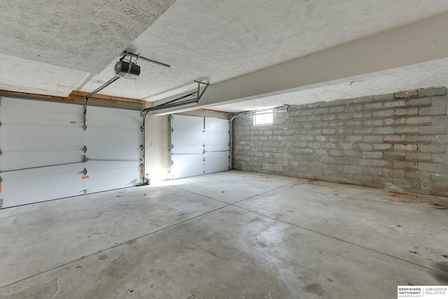 garage with a garage door opener and concrete block wall