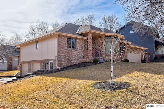 view of front of home with a front lawn, brick siding, and an attached garage