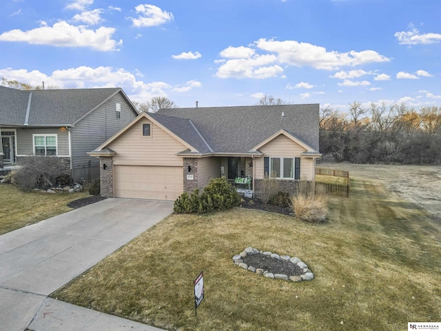 view of front facade with driveway, an attached garage, a front lawn, and a shingled roof