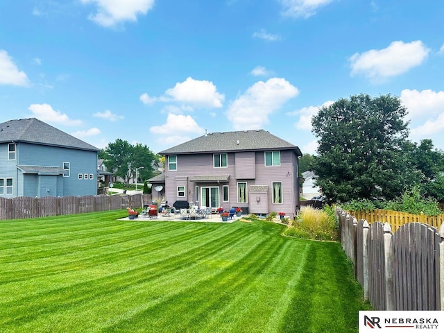 back of property with a yard, a fenced backyard, and a patio