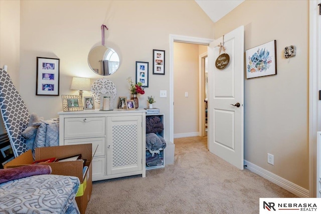 bedroom with light colored carpet, baseboards, and vaulted ceiling