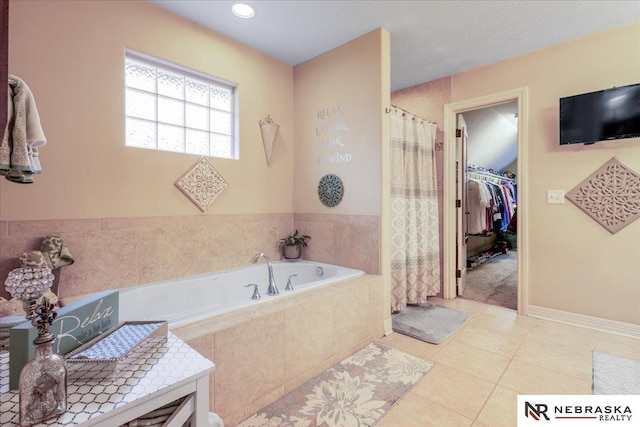 bathroom featuring a shower with curtain, baseboards, tile patterned flooring, a walk in closet, and a bath